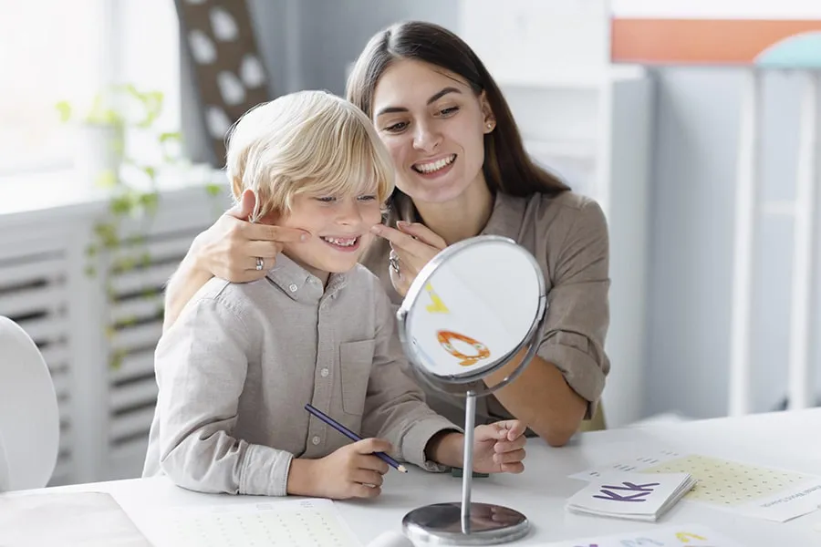 woman-doing-speech-therapy-with-little-boy-her-clinic-min